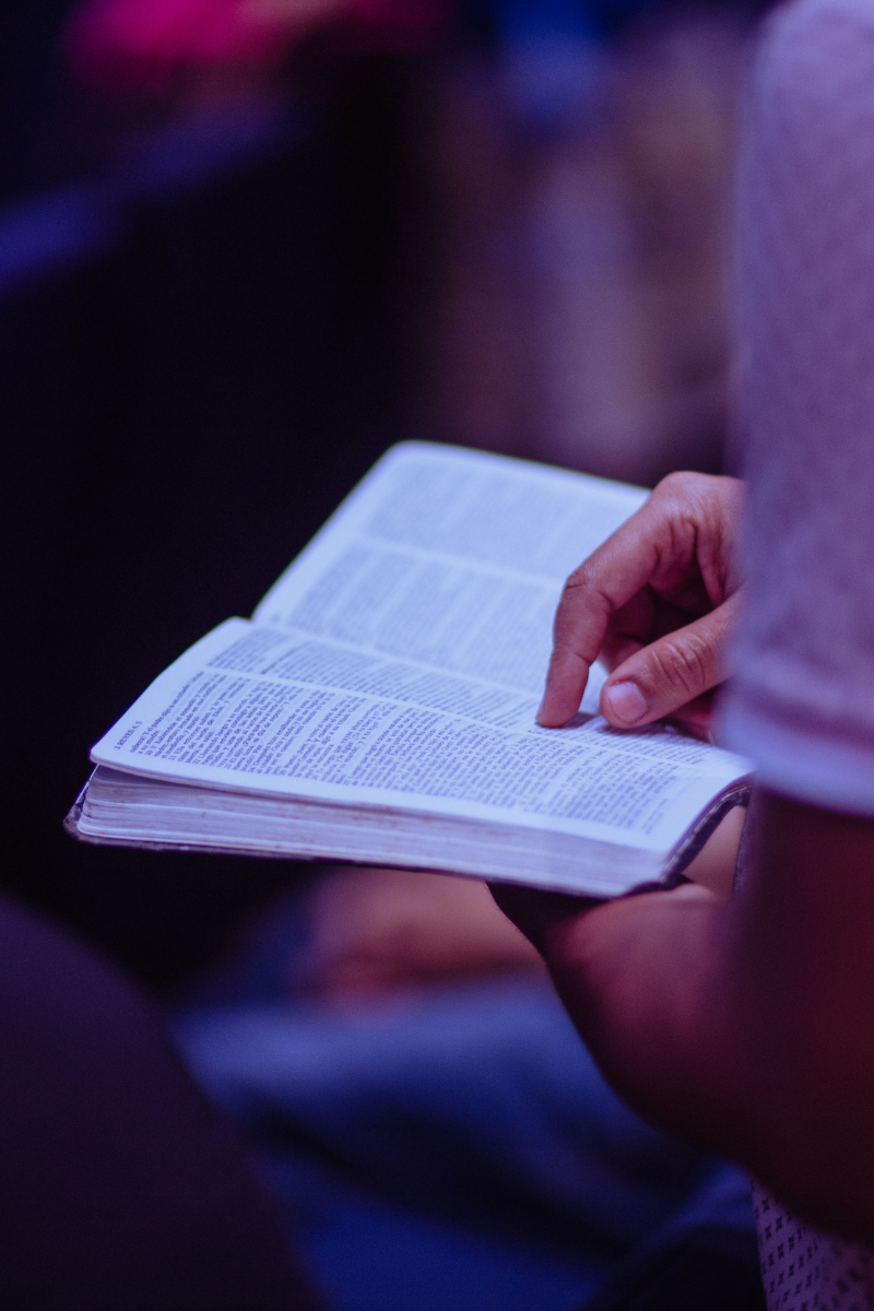Imagem de uma pessoa usando celular com Bíblia aberta – falar de Jesus nas redes sociais